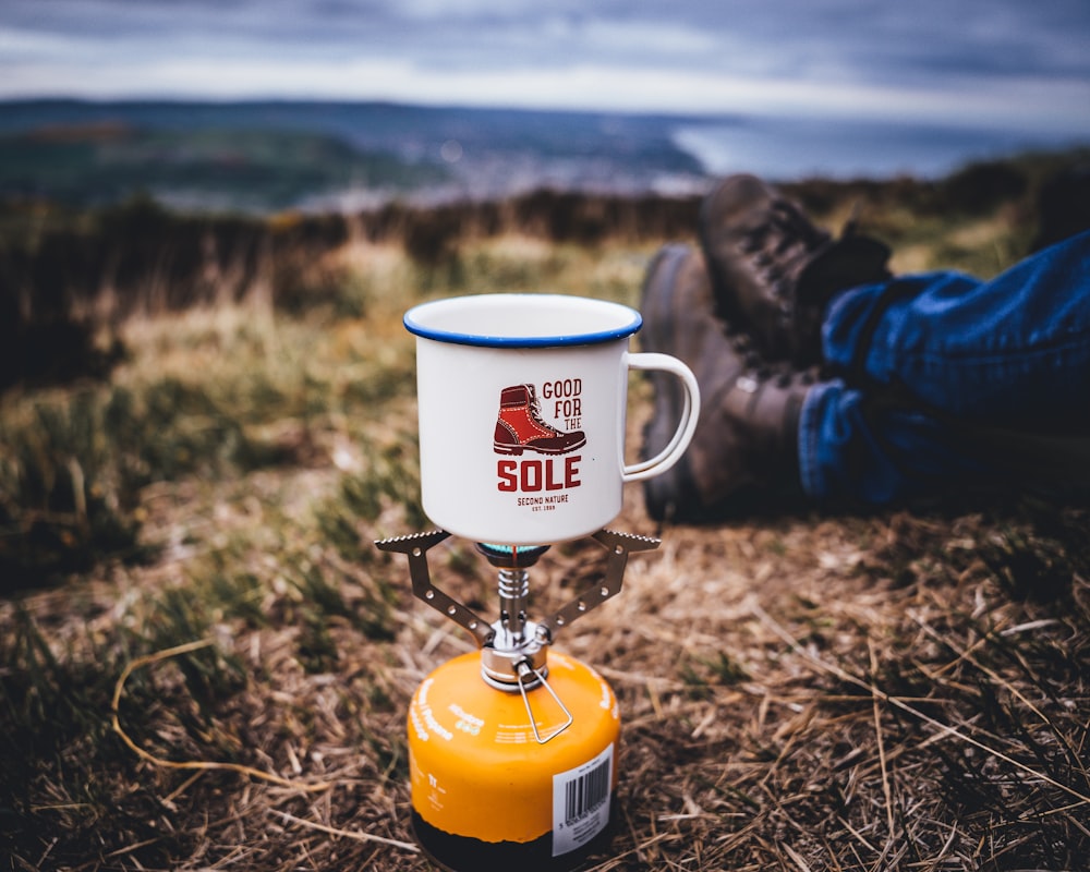 white and yellow ceramic mug on yellow and red stand