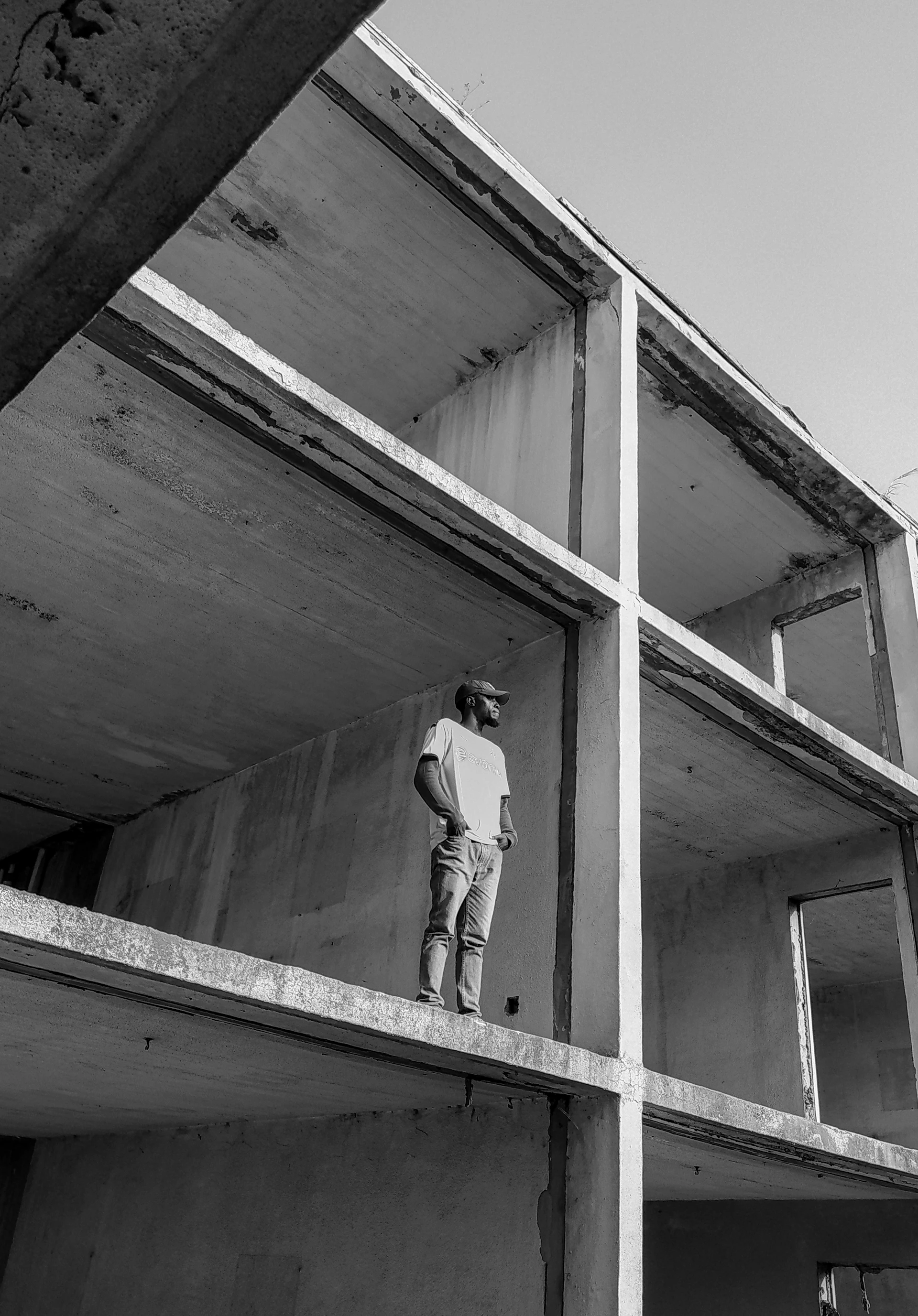 man in white shirt and black pants standing on white wooden window