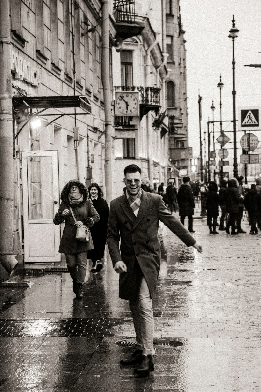 grayscale photo of man and woman standing on street