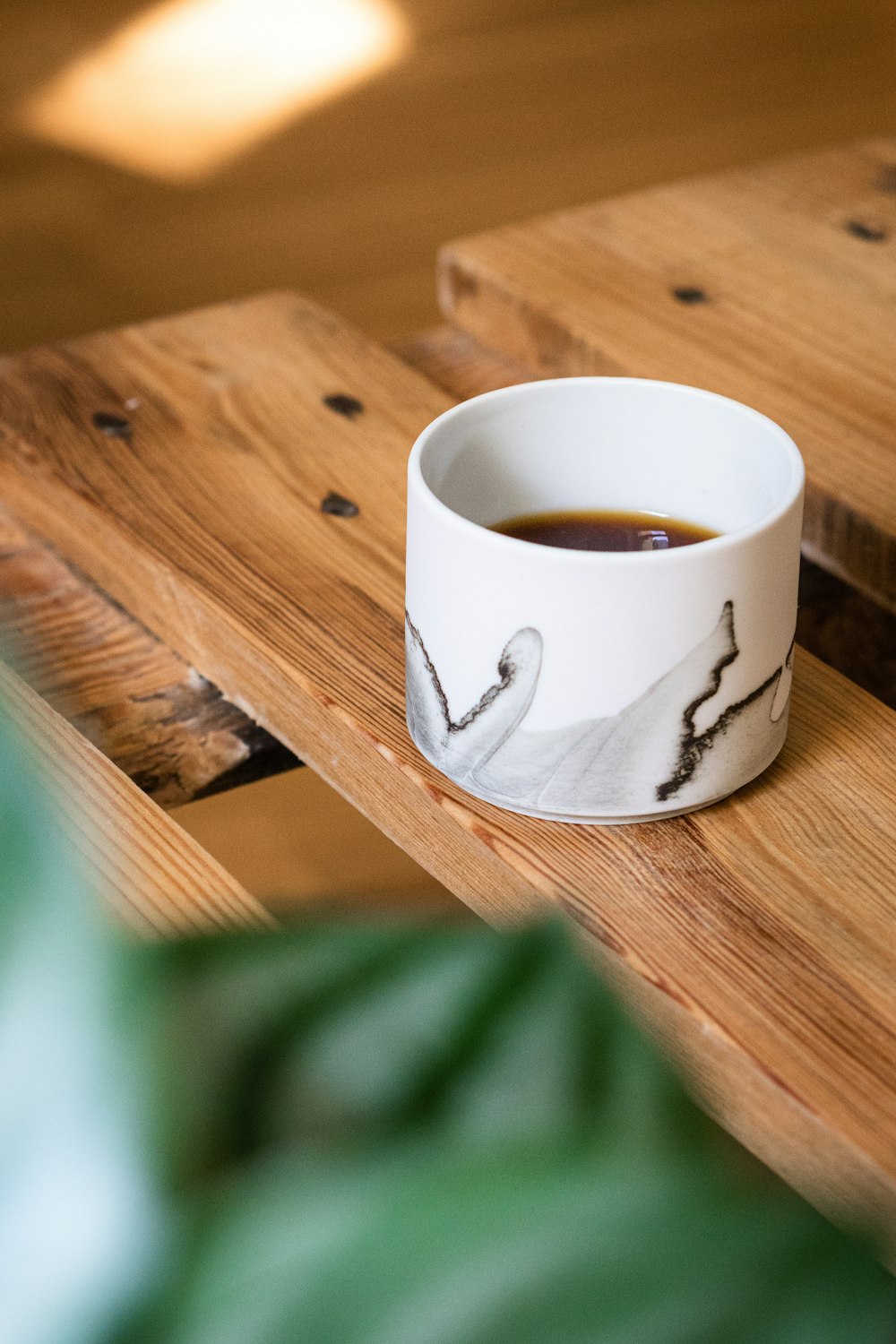 white ceramic mug on brown wooden table