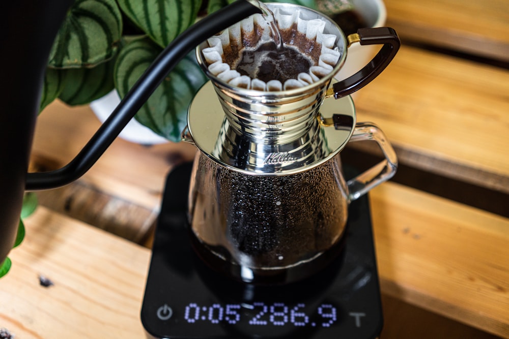 clear glass mug with coffee on black ceramic saucer