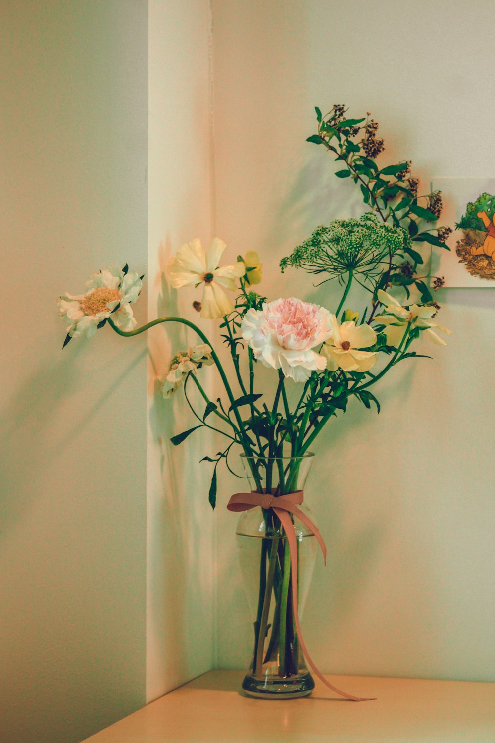 white and pink flowers in clear glass vase