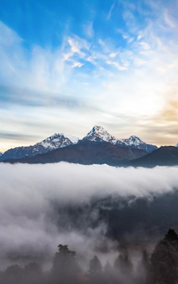 snow covered mountain under cloudy sky during daytime