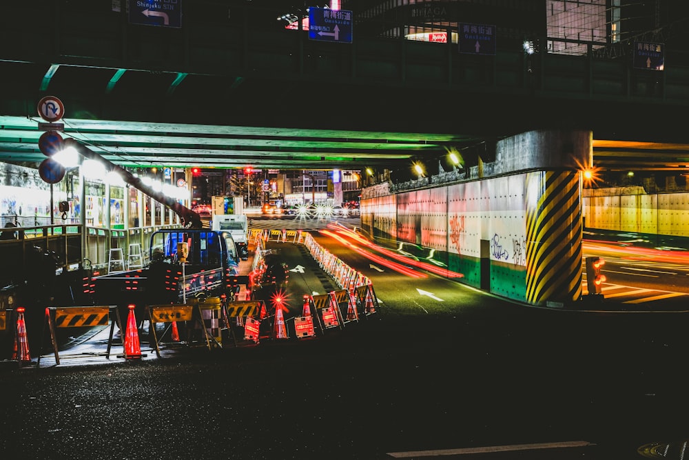 people sitting on red plastic chairs in front of white and green train during night time