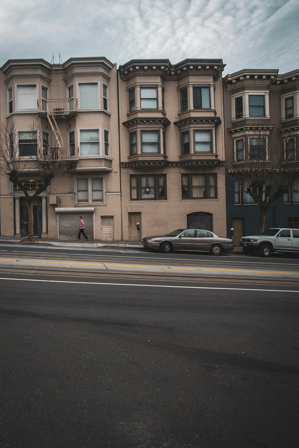 cars parked in front of brown building