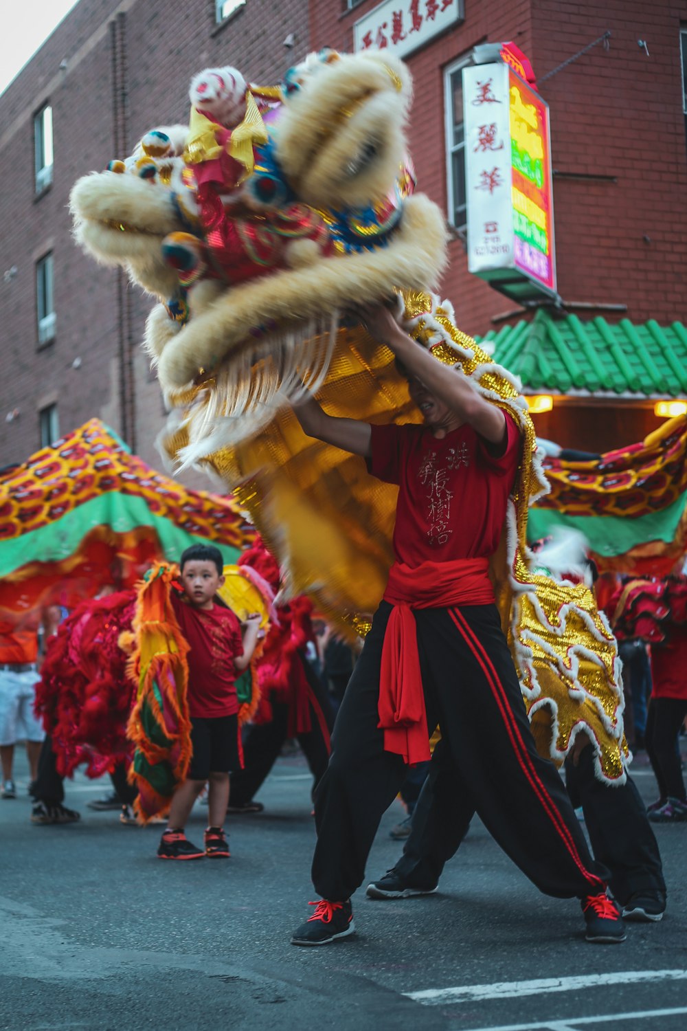 Personas con vestimenta tradicional roja y marrón caminando por la calle durante el día