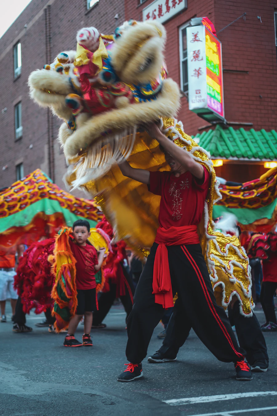 Lion dancers in red and gold costumes parading through Chinatown