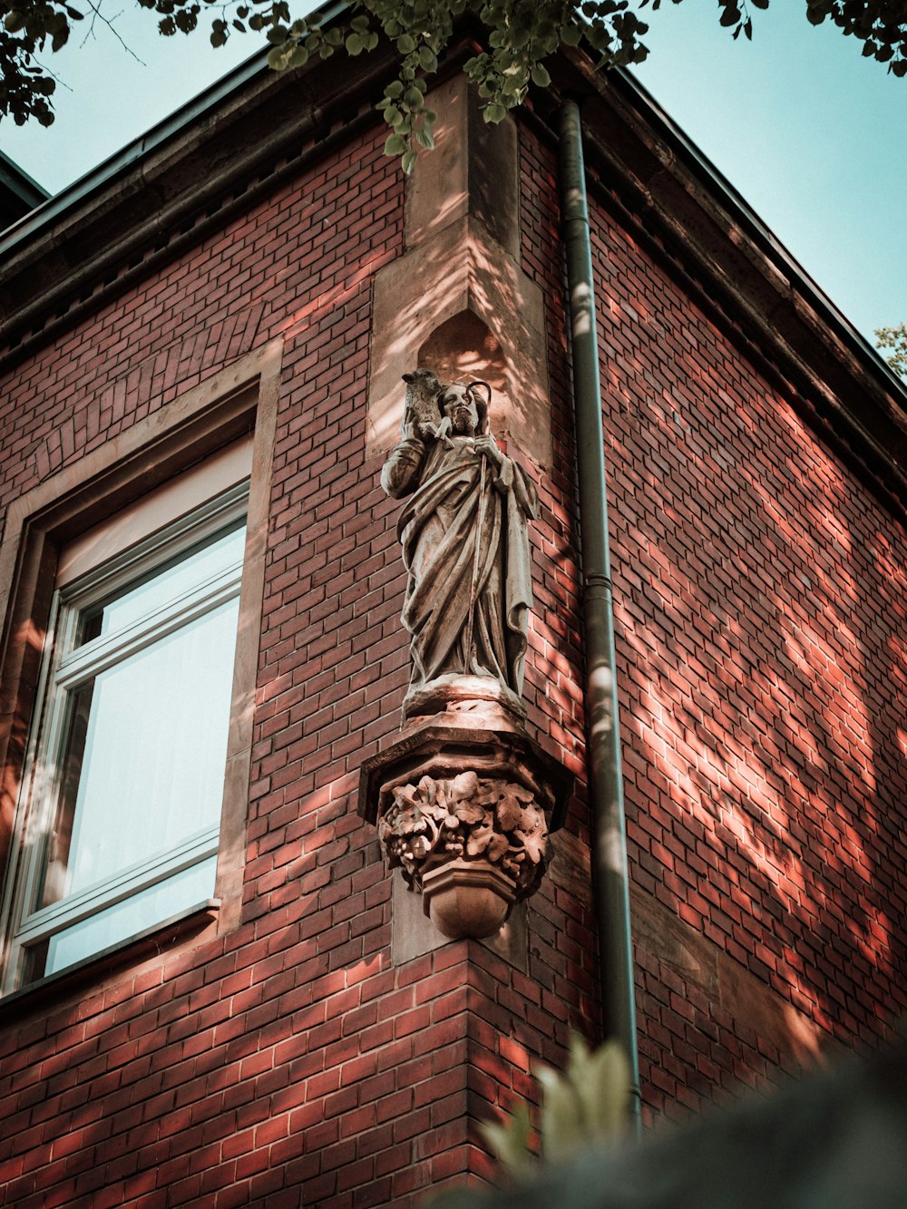 brown concrete statue of man on brown brick building