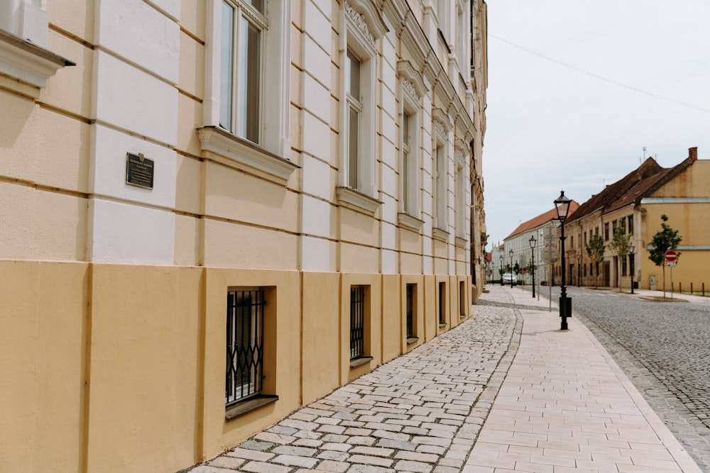 people walking on sidewalk near beige concrete building during daytime