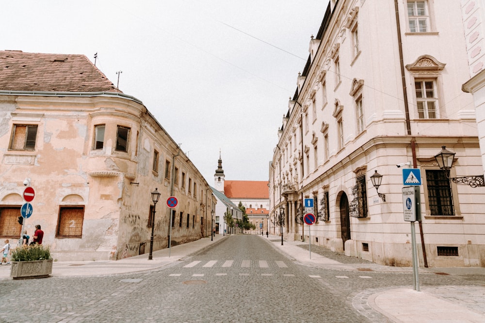 empty road in between of concrete buildings during daytime