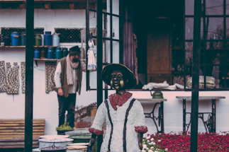 A cozy workspace with vintage costumes hanging and a friendly volunteer ready to assist.