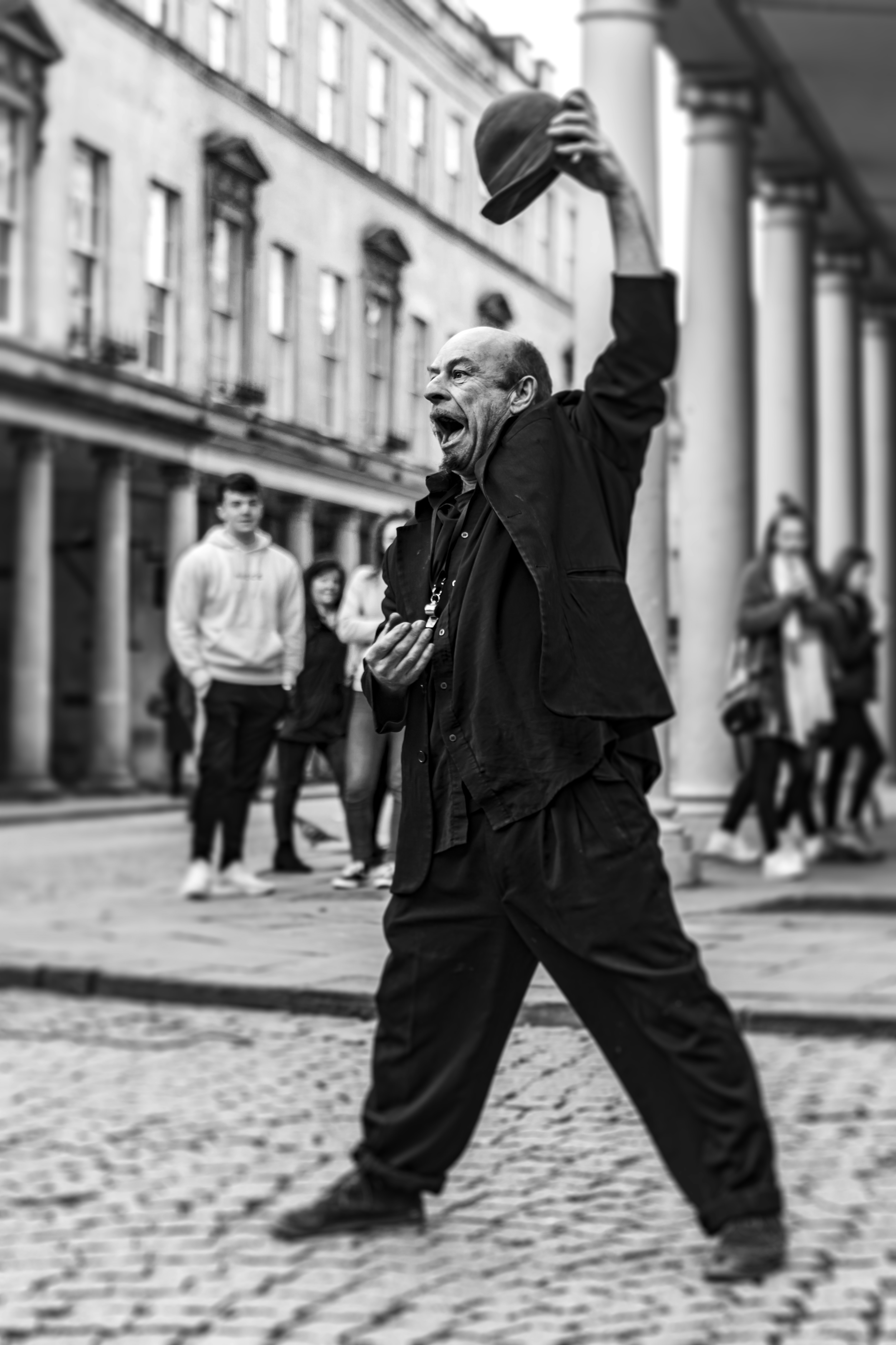 Street performer with fire, unicycle, sword and torches on the streets of Bath, England, UK during February 2020.