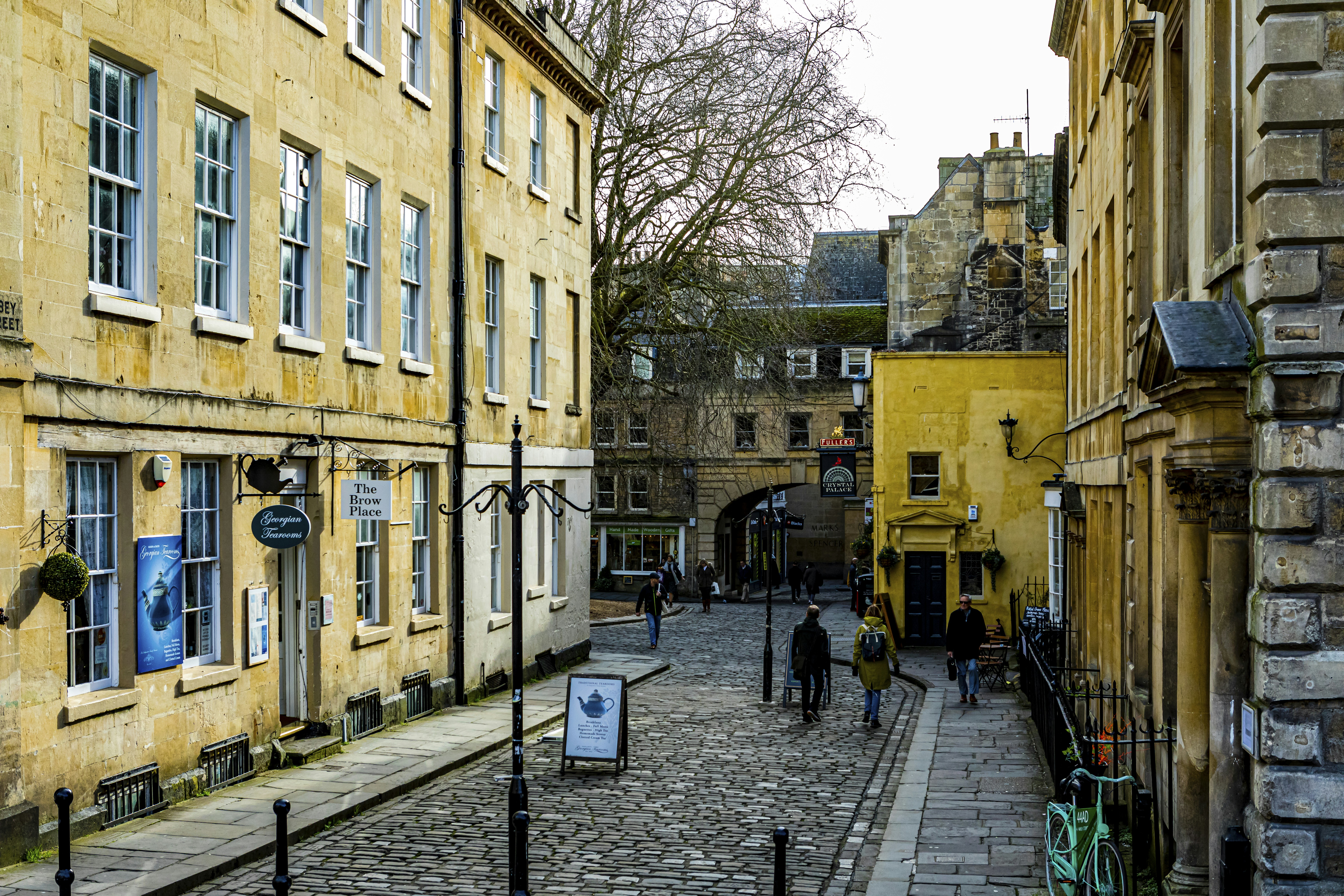 brown concrete building near trees during daytime, Side street in picturesque lovely historic city of Bath England UK, February 2020.