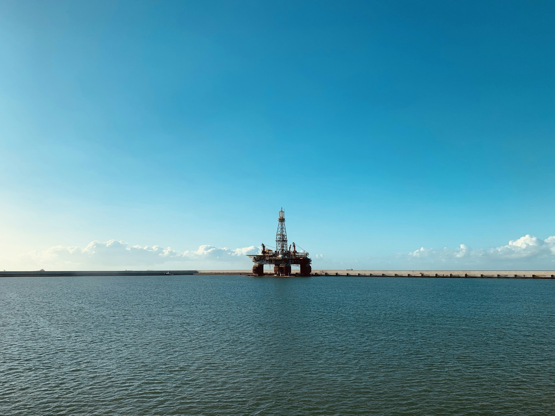 red and white ship on sea under blue sky during daytime