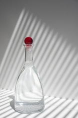 clear glass bottle with red lid