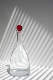 clear glass bottle with red lid