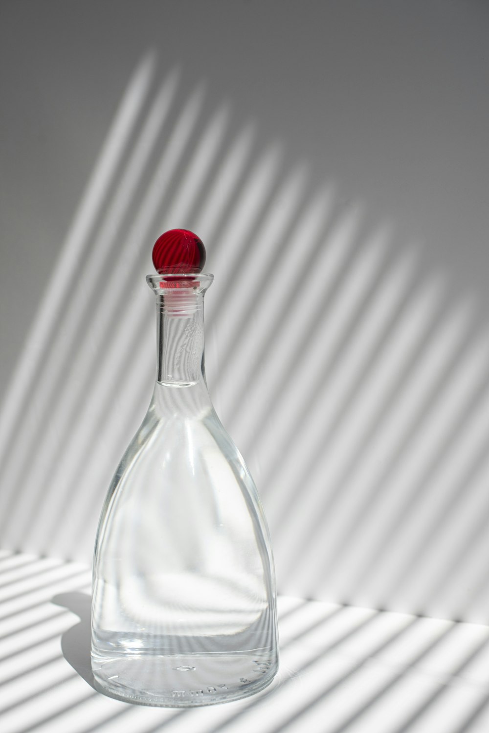 frasco de vidro transparente com tampa vermelha