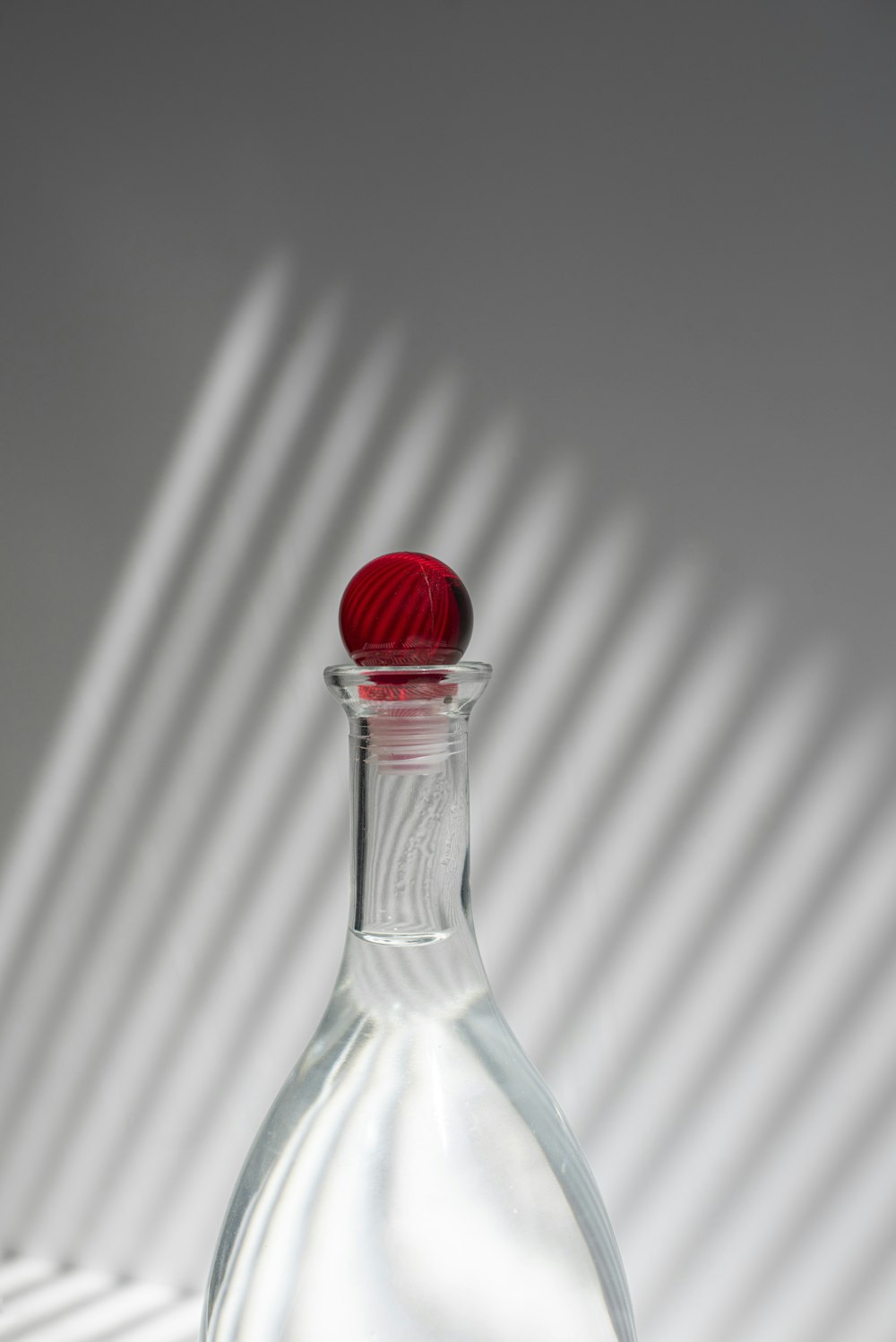 clear glass bottle with red lid