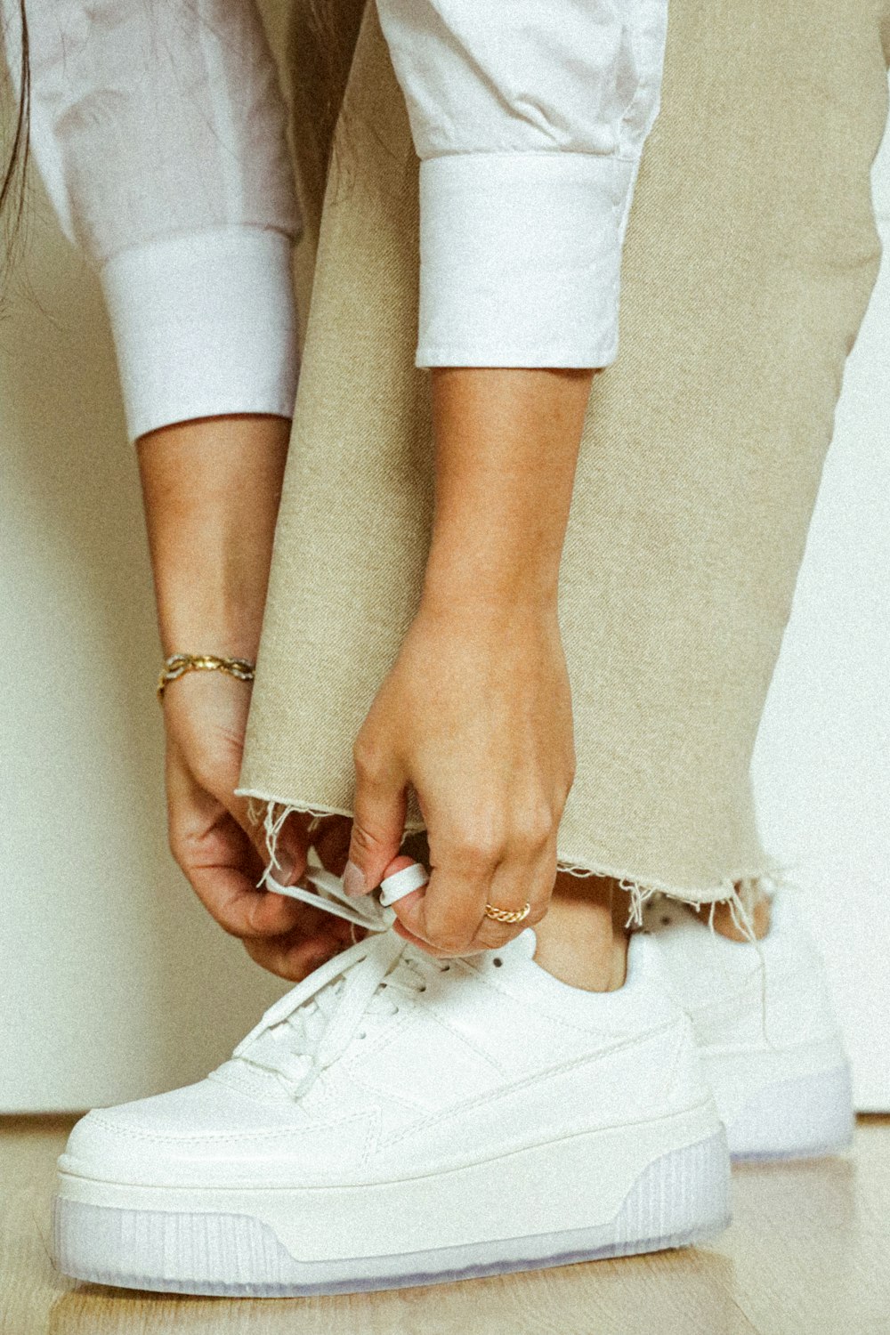 Mujer con pantalones blancos con pulsera de plata y oro