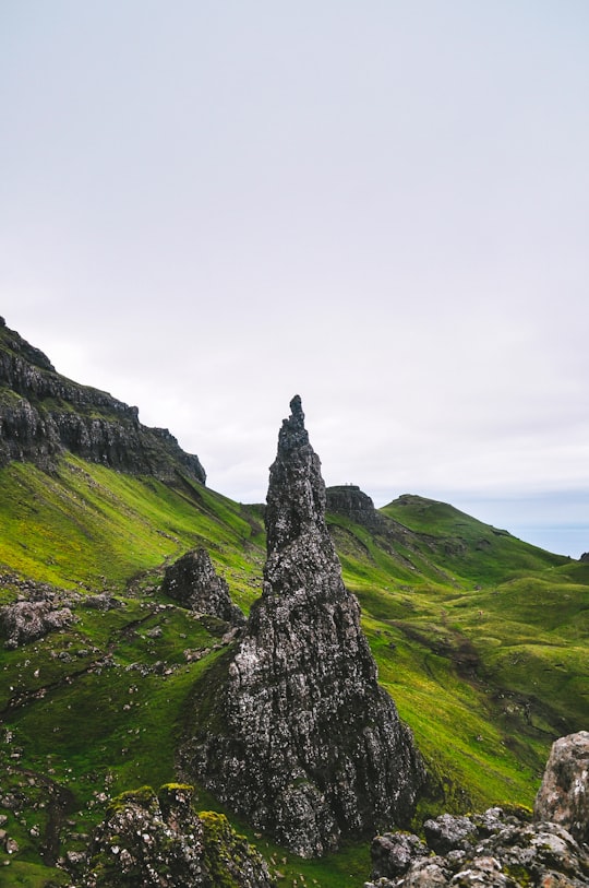 green grass covered mountain under white sky during daytime in The Storr United Kingdom