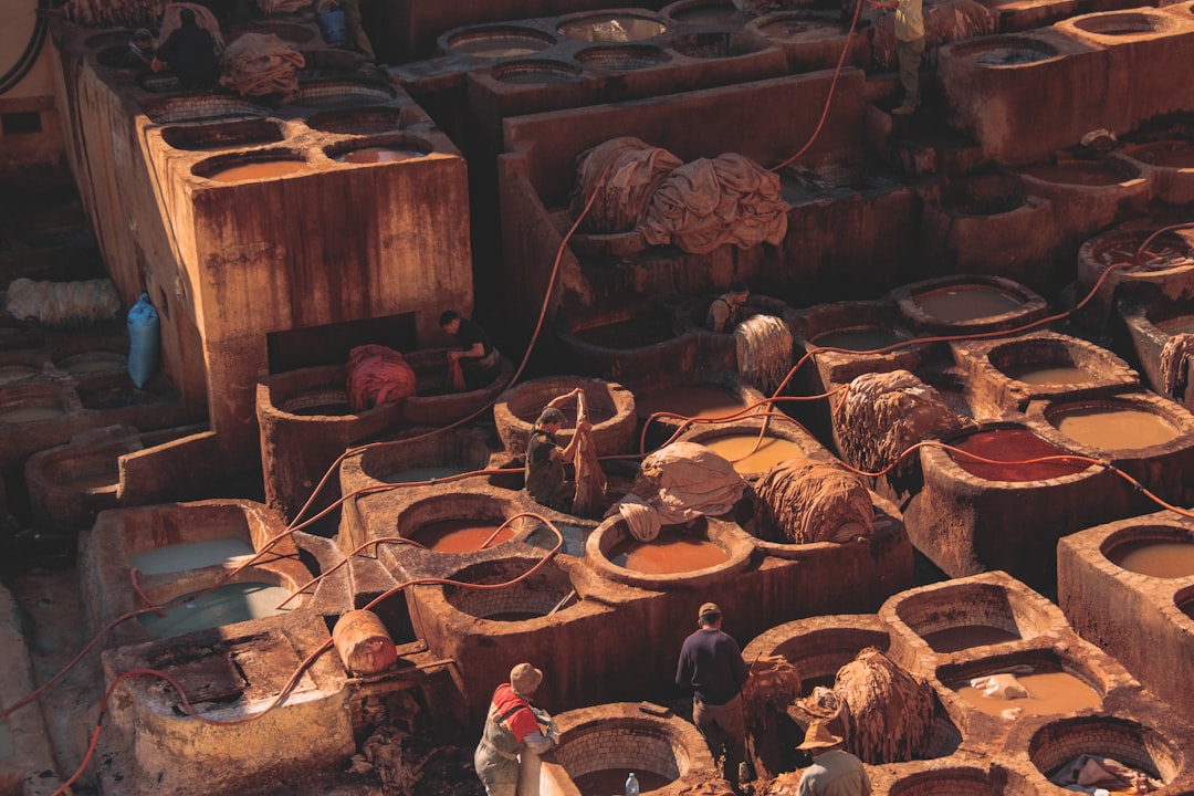 man in brown jacket standing near brown wooden barrels