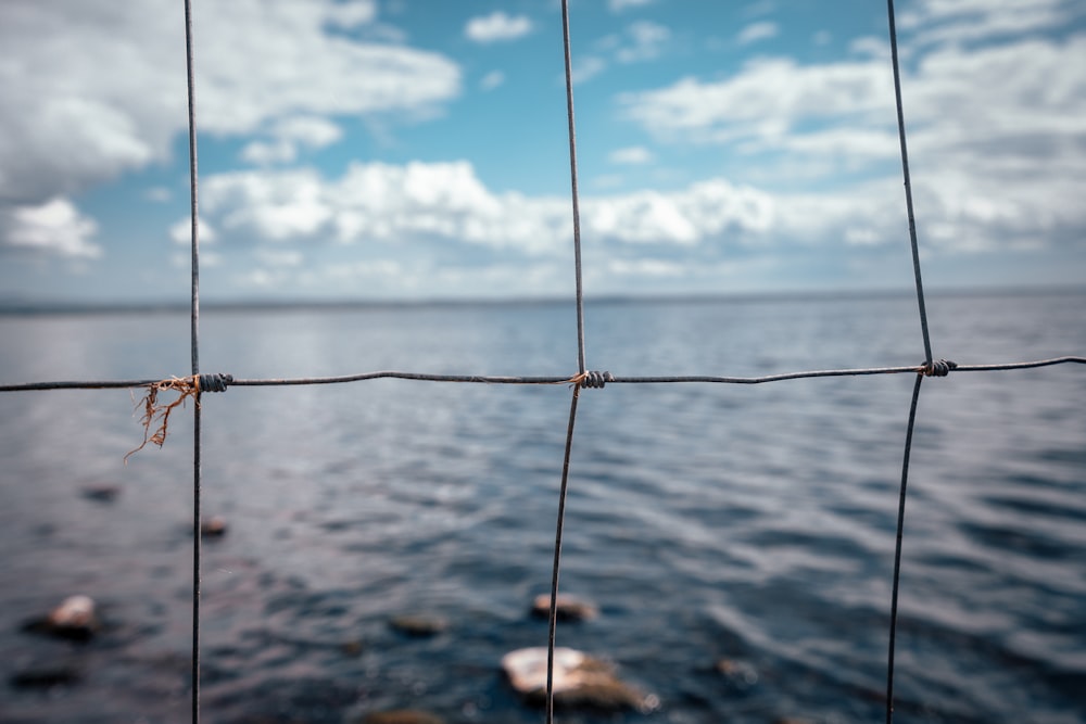 black rope on body of water under blue and white cloudy sky during daytime