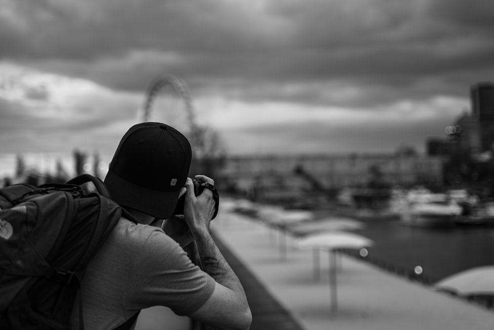 grayscale photo of person wearing cap and hoodie