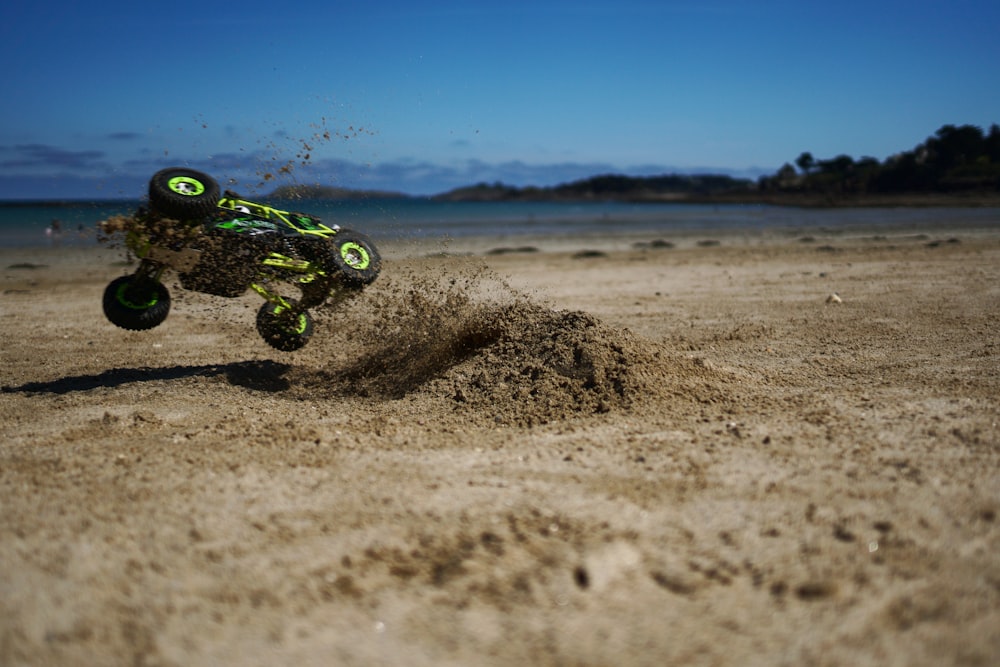 moto de terra verde e preta do motocross na areia marrom durante o dia