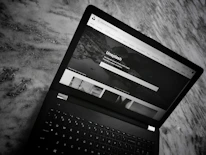 Close-up of a modern laptop screen displaying the Cinefama News homepage.