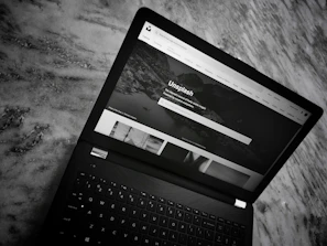 A minimalist black and white layout of the online store homepage on a laptop screen.