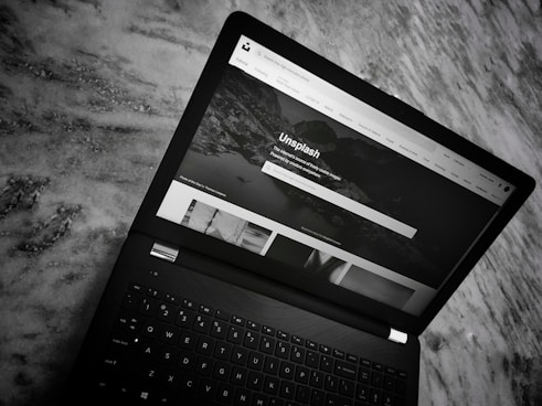 A sleek, minimalist black and white website layout on a laptop screen.