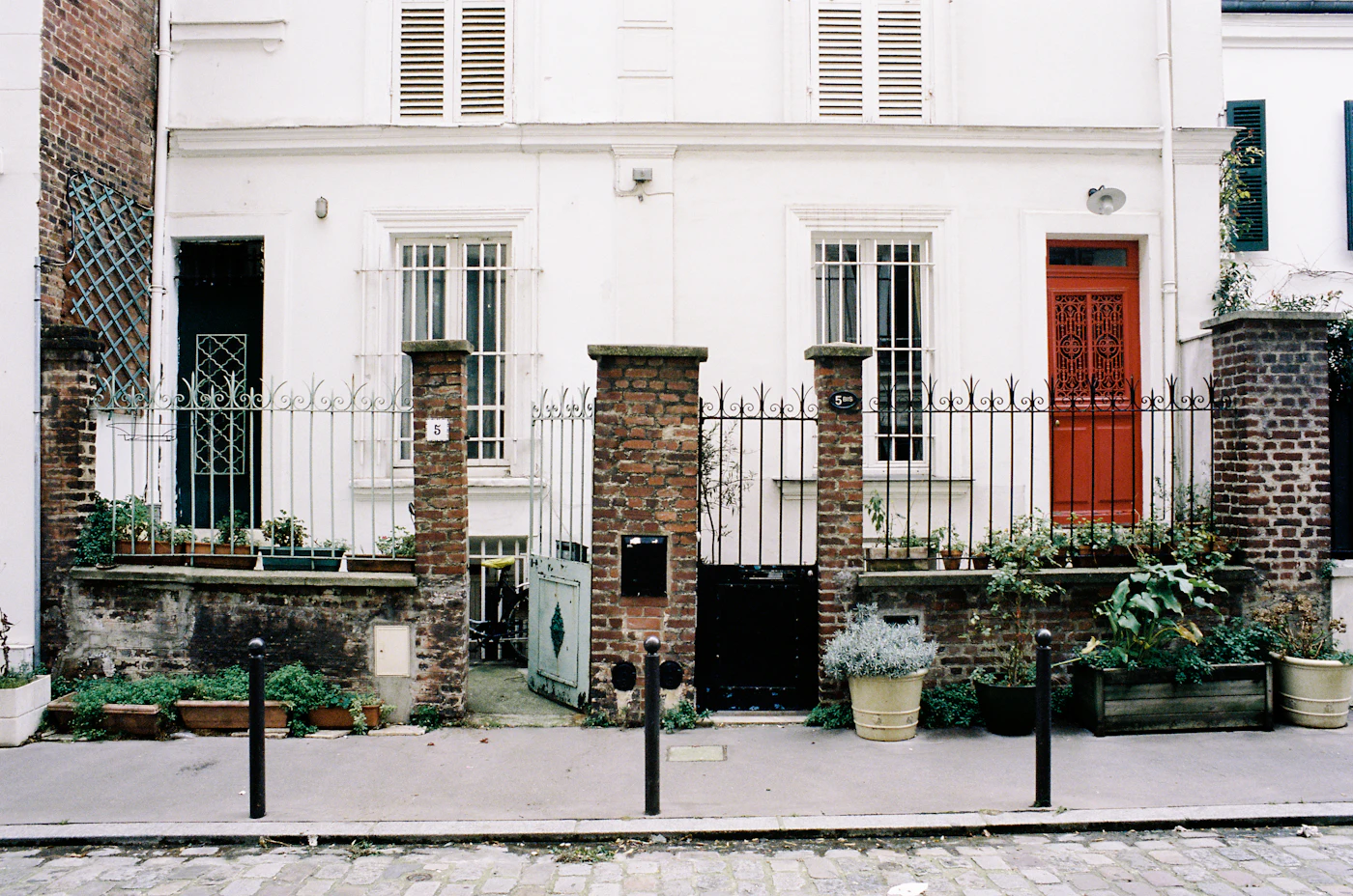 Petite rue pavee bordee de maisons de ville basses, typique des villas parisiennes