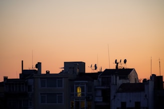 Night view of antennas glowing softly with city lights in the background.