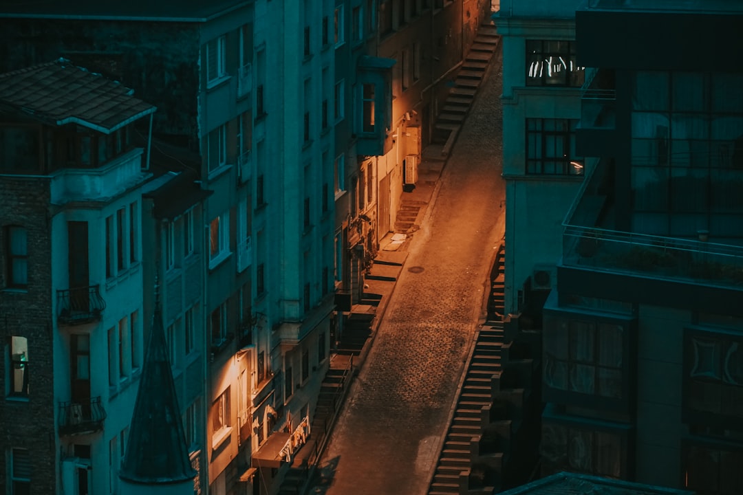 empty street between concrete buildings during night time