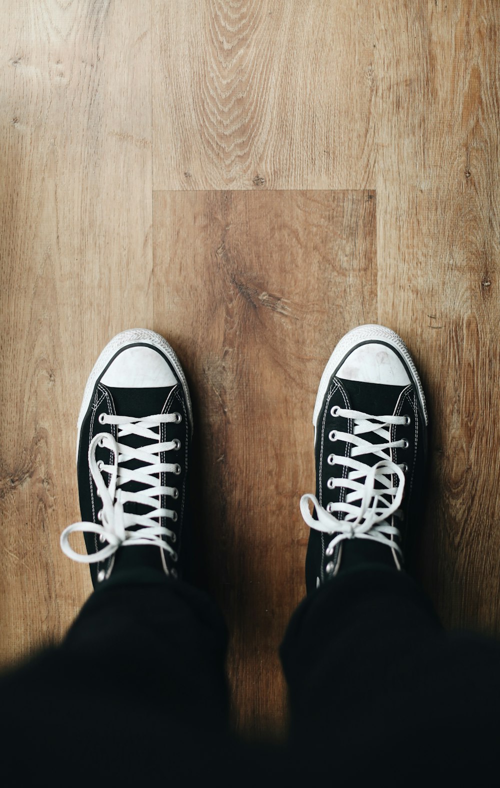 person wearing black and white converse all star sneakers