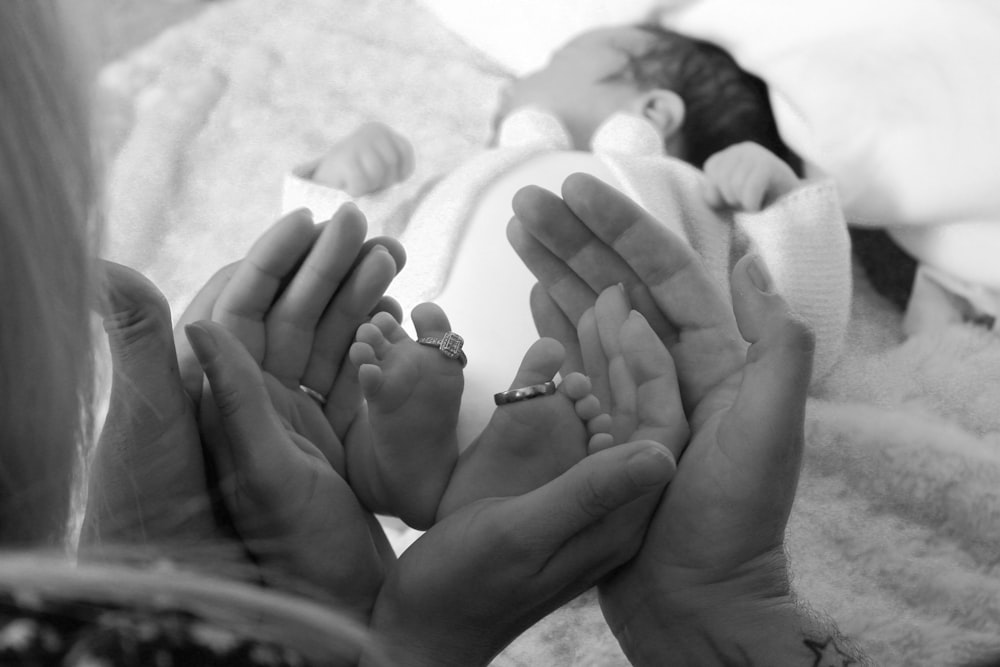 grayscale photo of woman and child holding hands