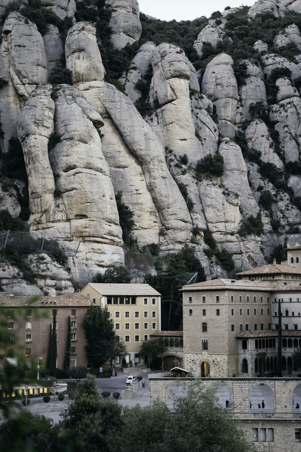 edifício de concreto branco perto da montanha rochosa cinza durante o dia