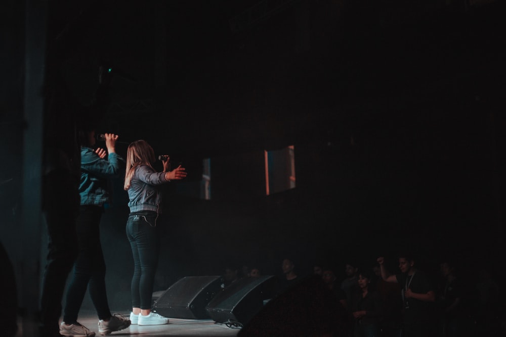 woman in blue denim jeans standing on stage