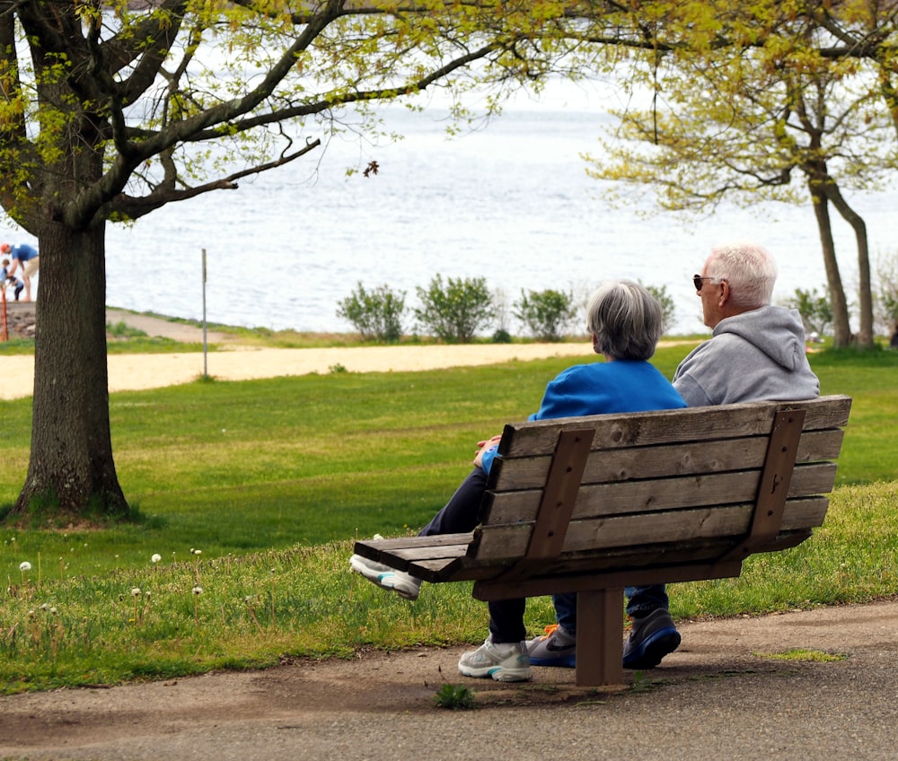 woman in blue shirt sitting on brown wooden bench