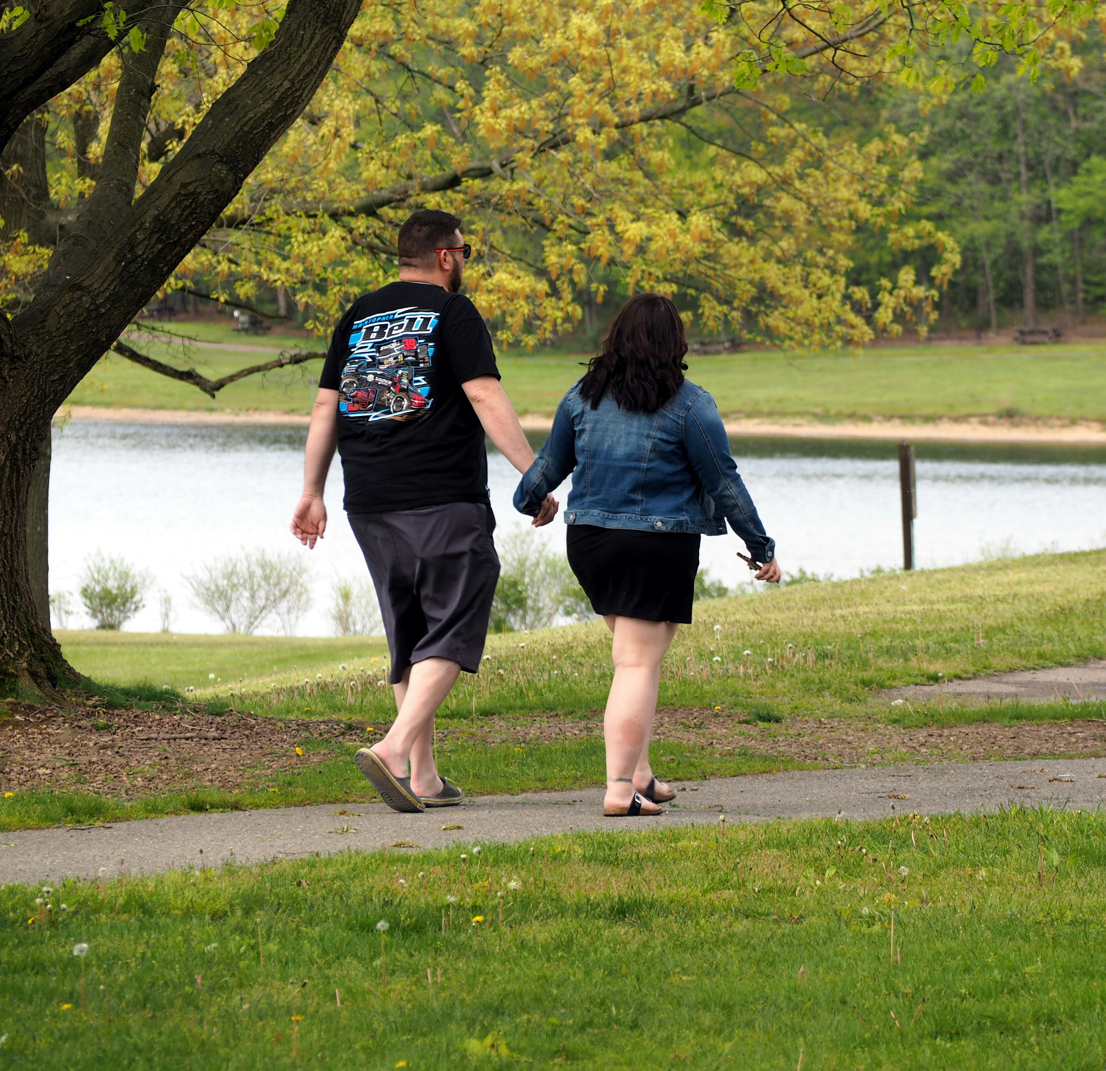 A young couple holding hands strolls a trail Saturday (May 16, 2020) paralleling the shoreline of Beltzville Lake at Beltzville State Park in Lehighton PA.