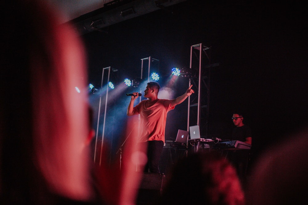 man in white shirt standing on stage