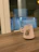 A cozy pastel-colored mug on a wooden desk with soft natural light.