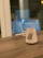 A cozy pastel-colored mug on a wooden desk with soft natural light.