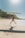 woman in black bikini holding white surfboard on beach during daytime