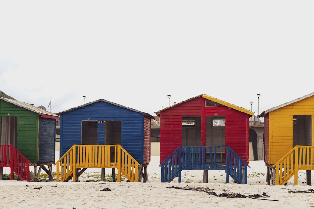 昼間の白い砂浜に青と茶色の木造住宅