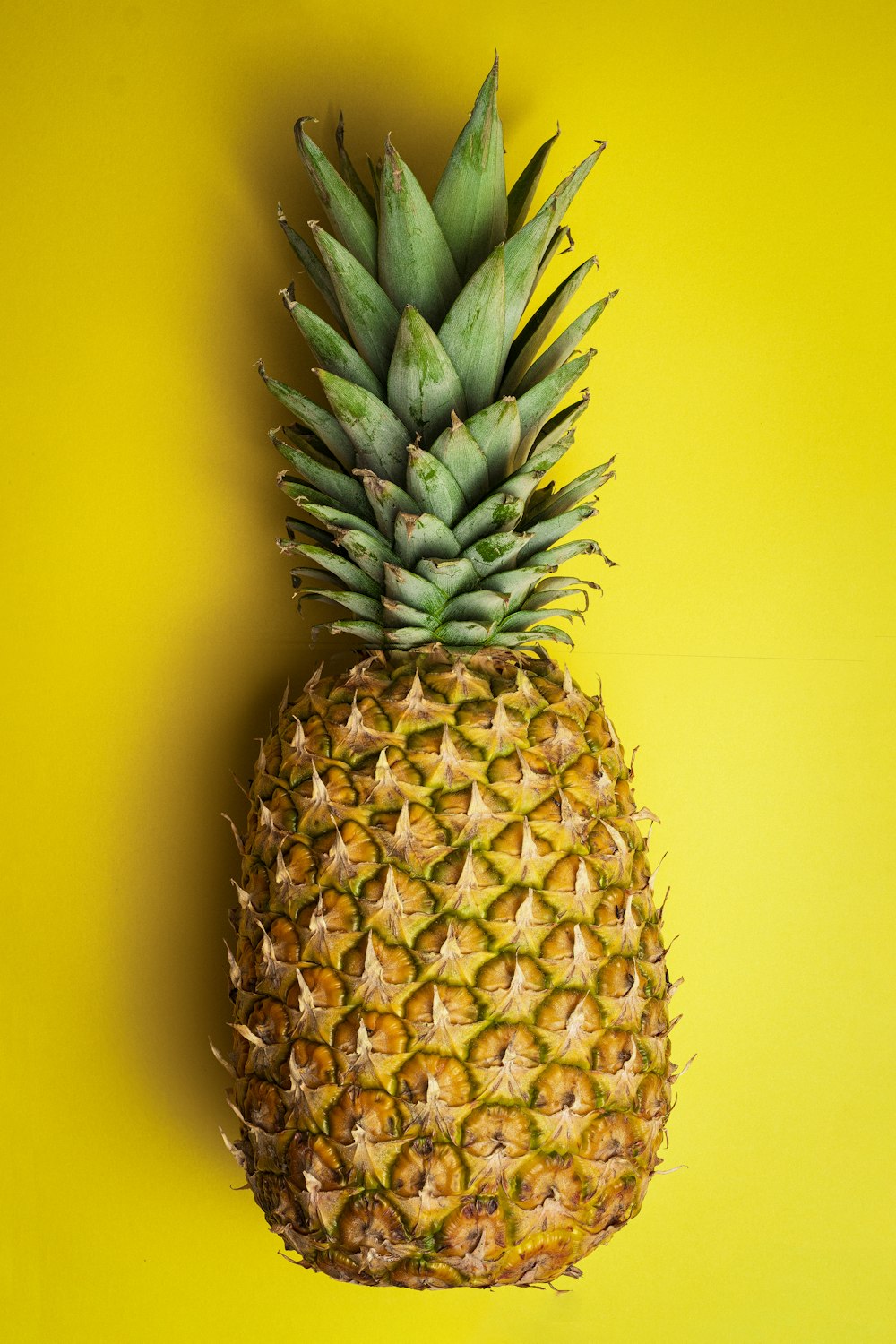 pineapple fruit on yellow surface