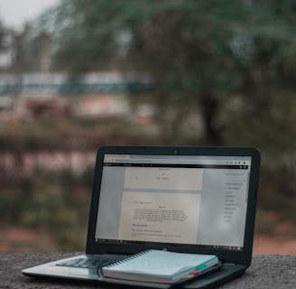 black laptop computer on brown wooden table