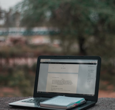 black laptop computer on brown wooden table