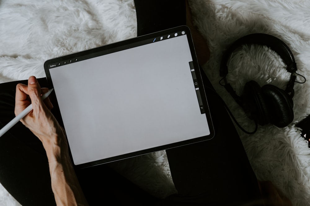 black tablet computer on white textile