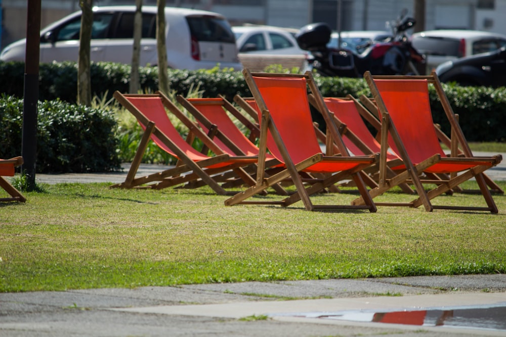 brown wooden folding chairs on green grass field during daytime